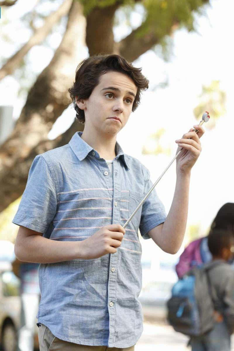 Young Actor Holding Lollipop Outdoors Wallpaper
