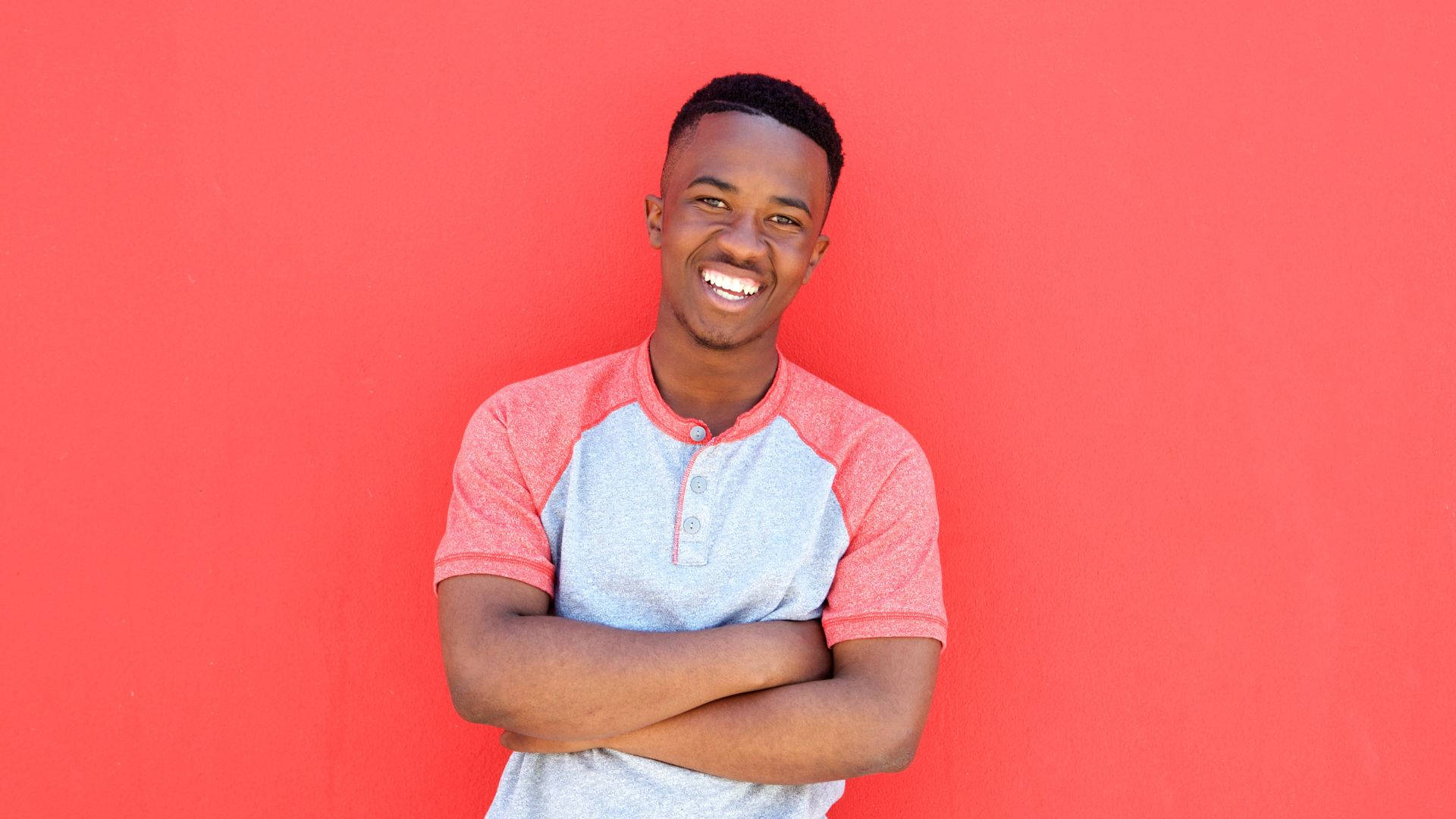 Unge afrikansk mand selvsikkert står i en livlig skov Wallpaper