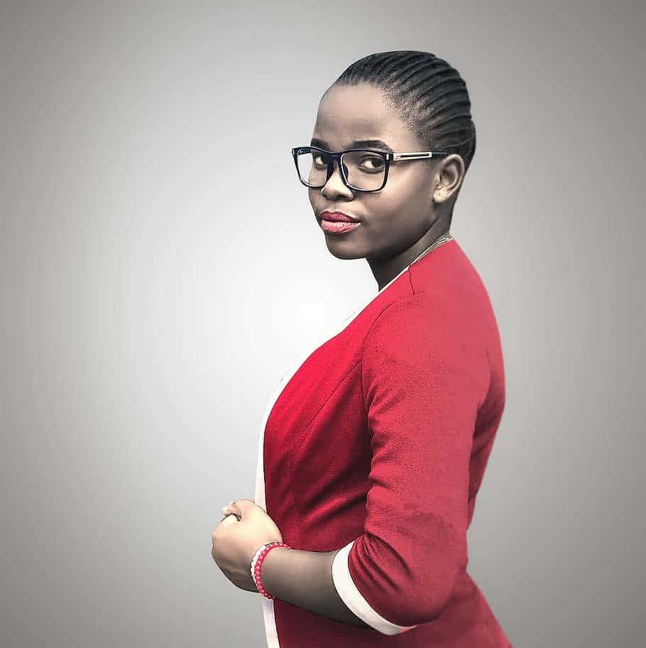 Unge sorte kvinde med briller og businessdragt stirrer fremad Wallpaper