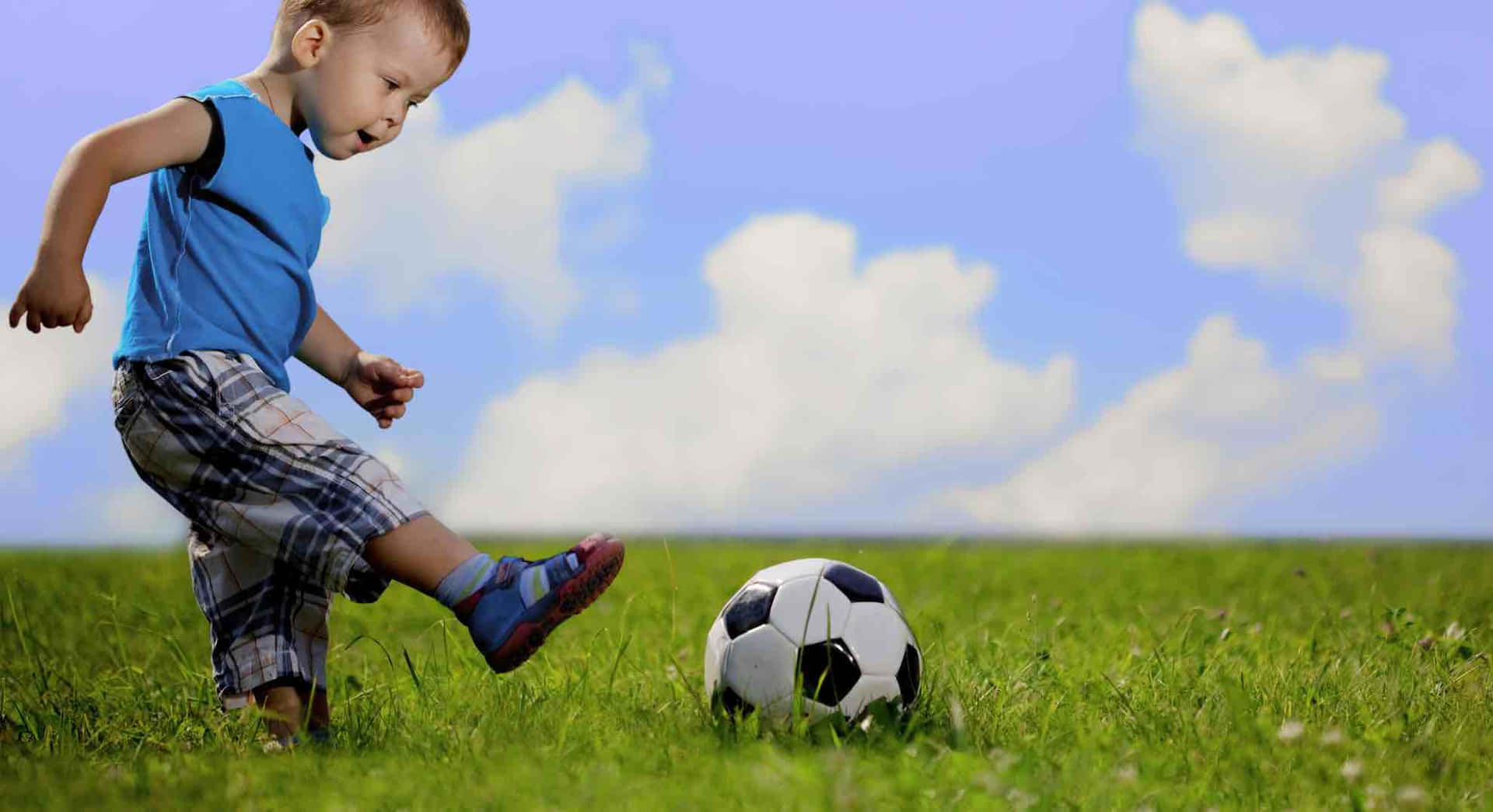 Young Child Playing Soccer Outdoors.jpg Wallpaper