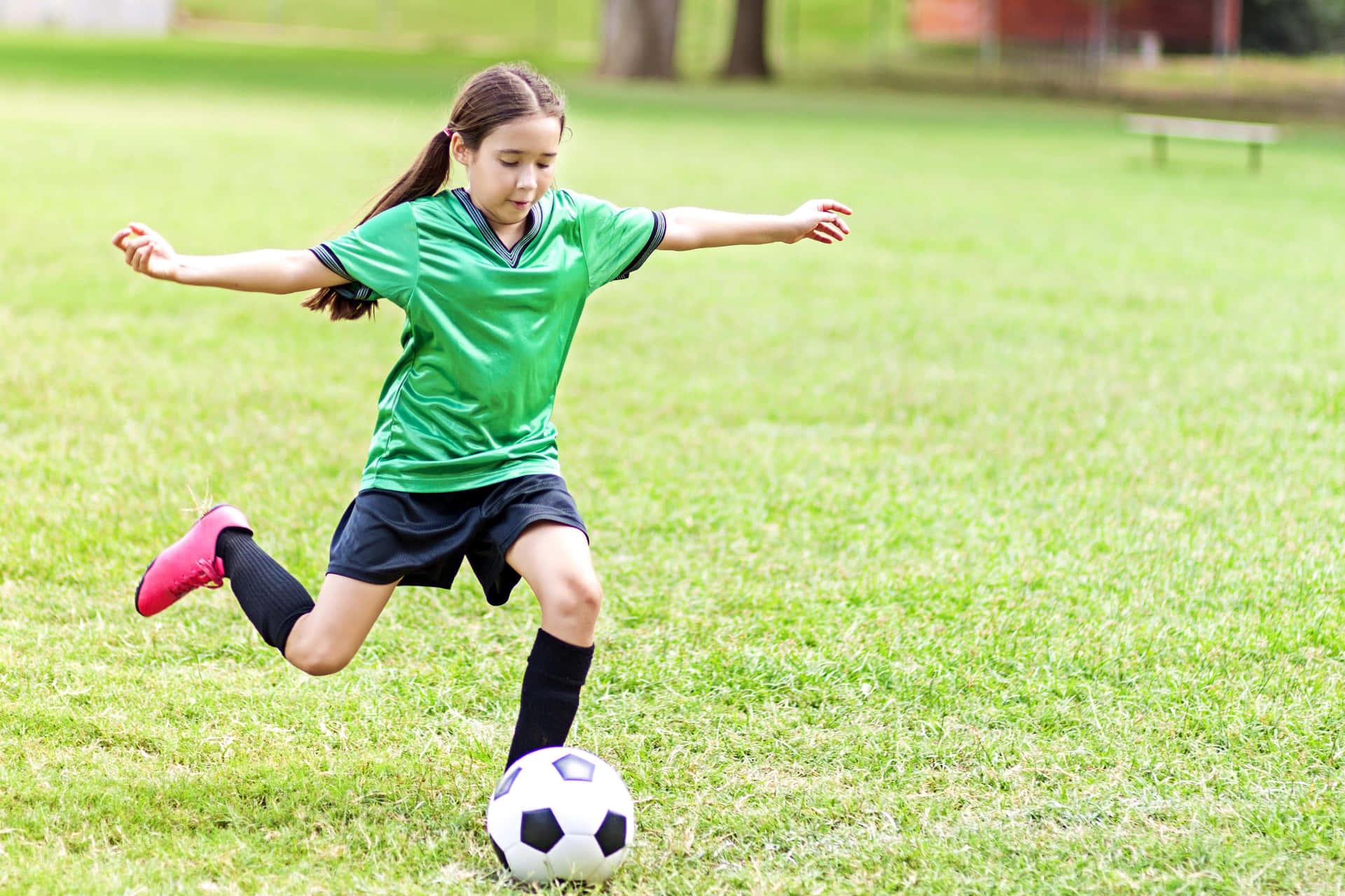 Young Girl Playing Soccer Outdoors.jpg Wallpaper