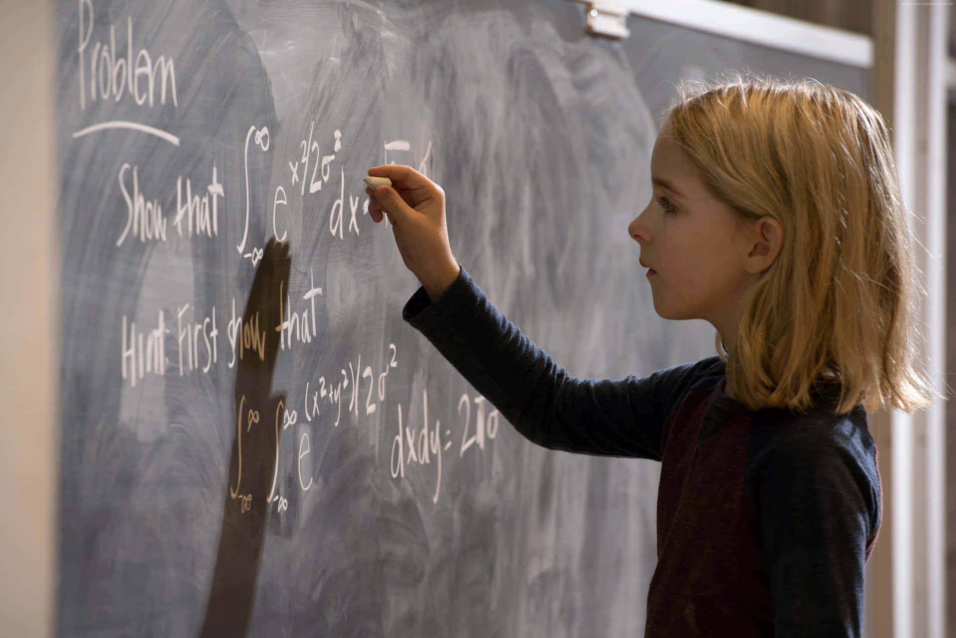 Young Girl Solving Math Problemon Blackboard Wallpaper