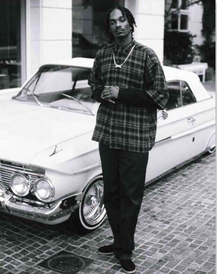 Snoop Dogg står ved siden af en klassisk bil. Wallpaper