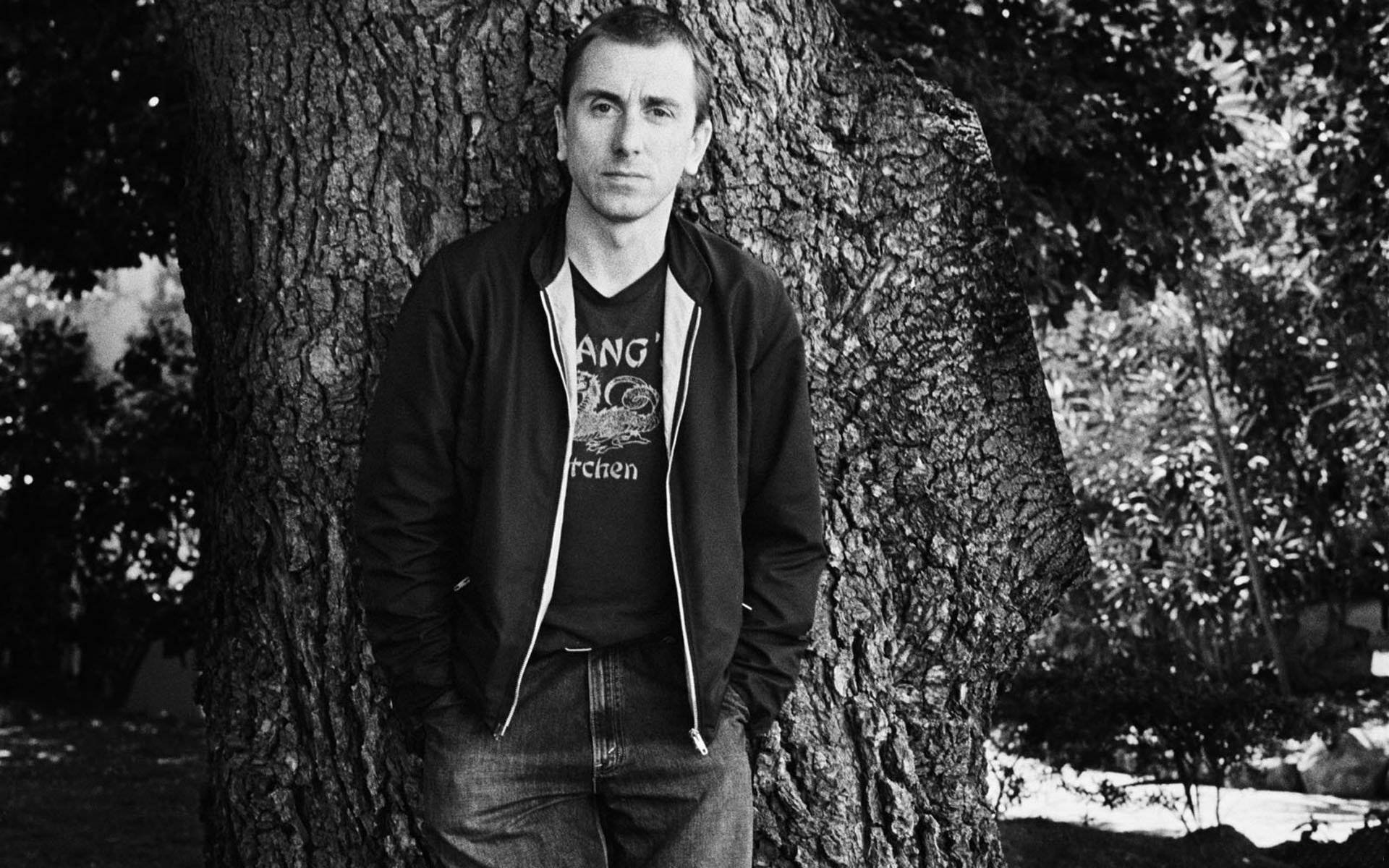 Young Tim Roth Posing By A Tree Wallpaper