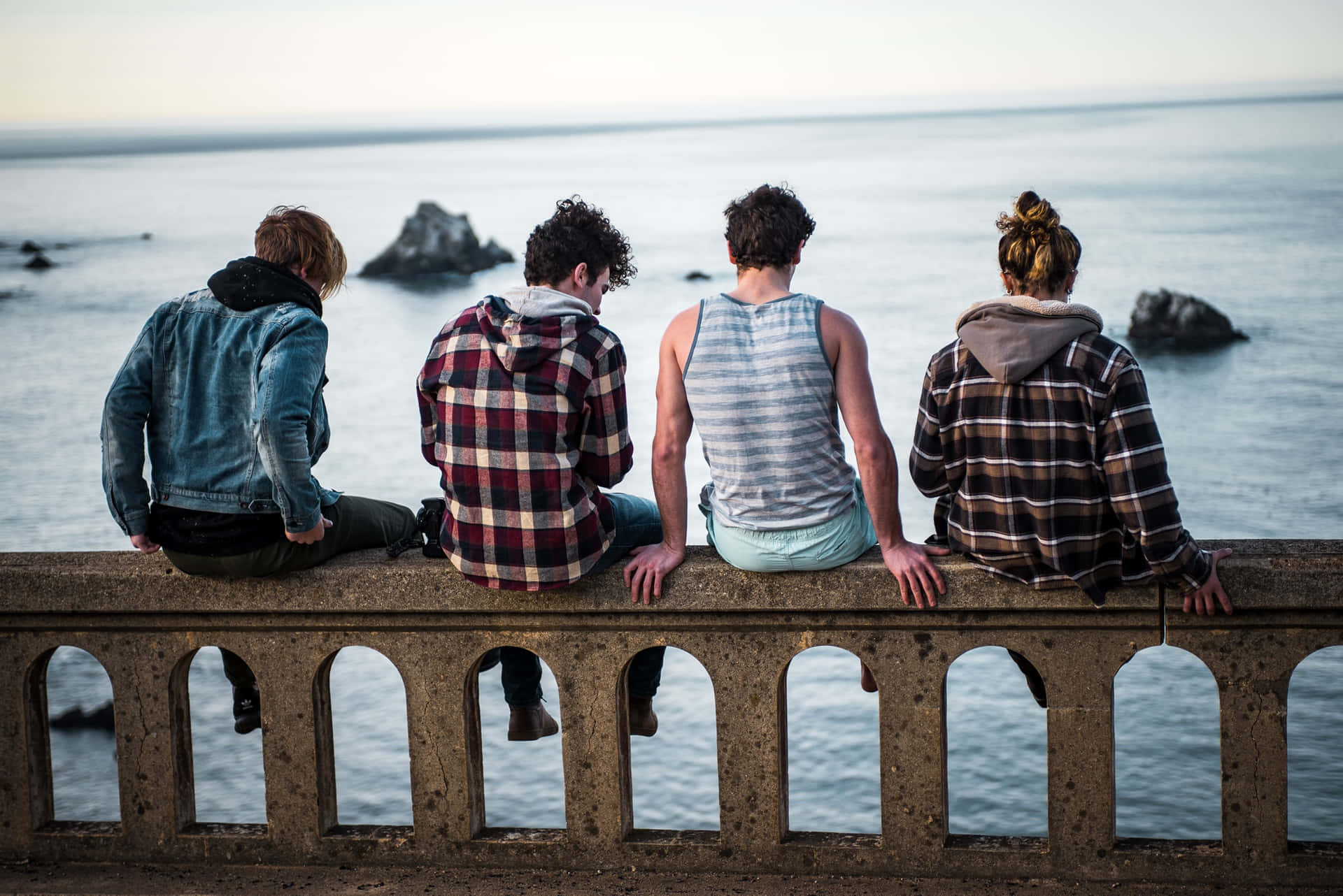 Youth Group Enjoying Seaside Sunset Wallpaper