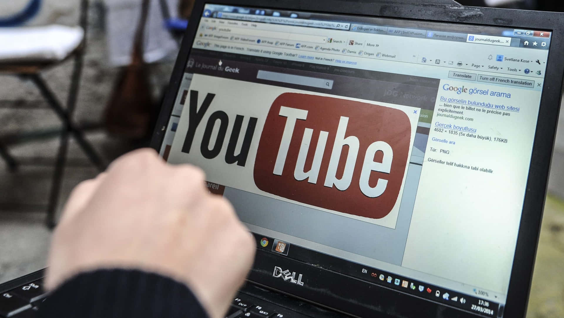 En person bruger en bærbar computer med YouTube-logo på.