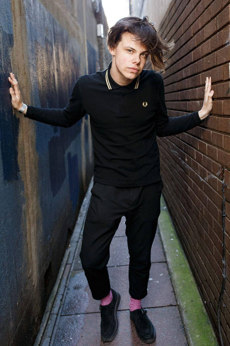 A Young Man In Black Standing In A Alleyway Wallpaper