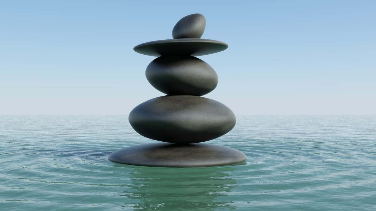 A Stack Of Black Stones In The Water