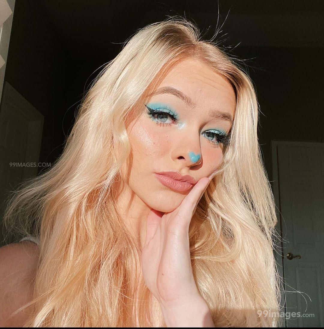 Einmädchen Mit Langen Blonden Haaren Und Blauem Augen-make-up Wallpaper