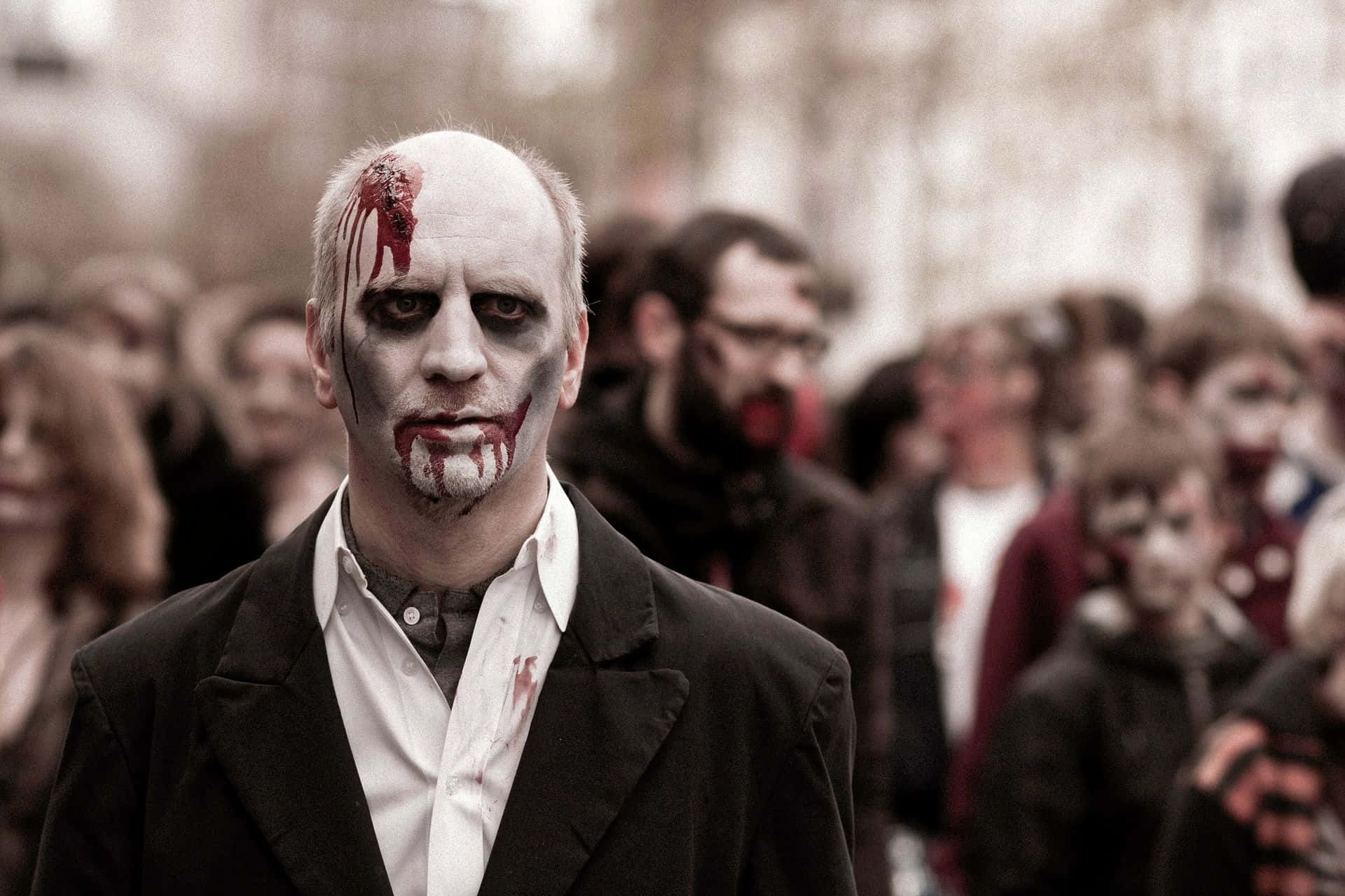A Man Dressed Up As A Zombie In A Crowd