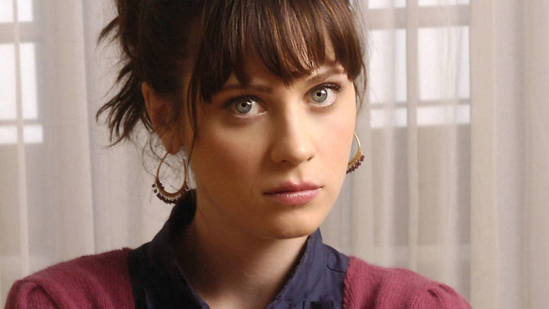 Zooey Deschanel With Hair Tied In Front Of Curtain Wallpaper