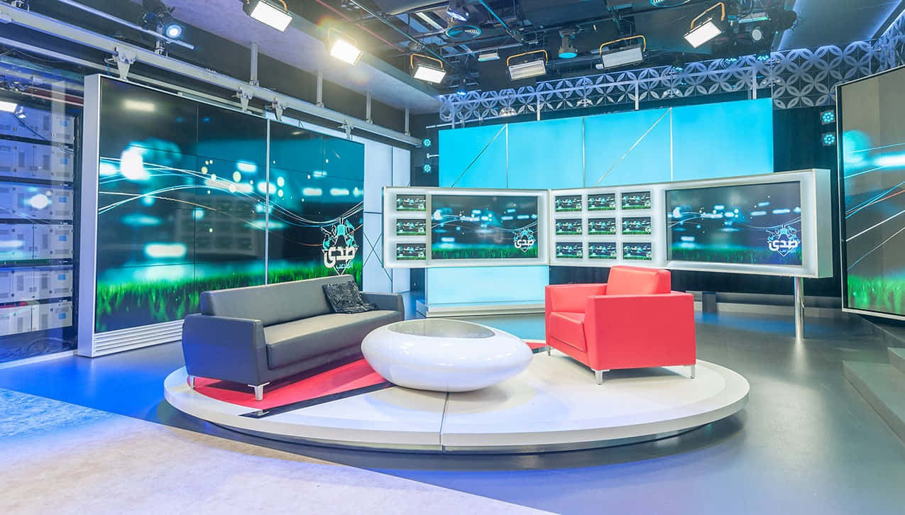 A Television Studio With A Large Screen And Chairs