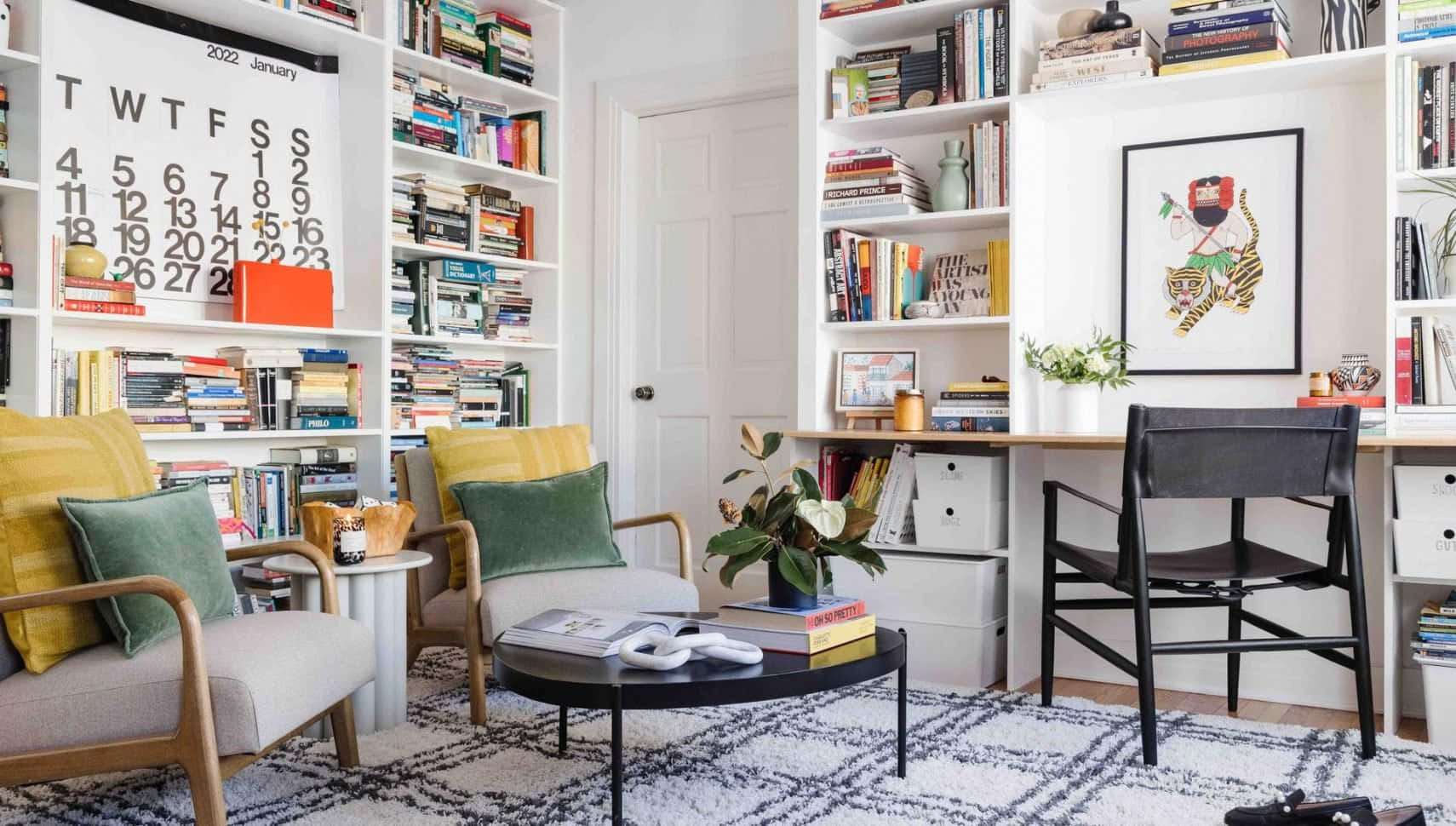 A Home Office With A Desk, Bookshelves And Chairs