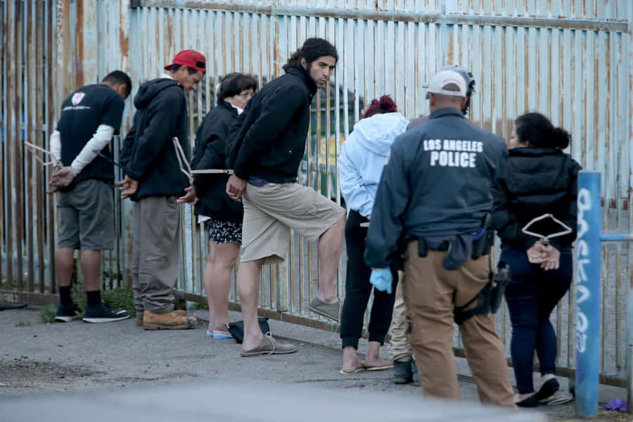 eineGruppe von Menschen, die in der Nähe eines Zauns steht