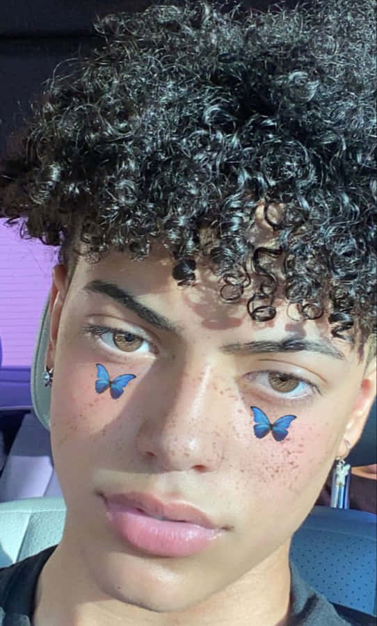 Junge mit lockigem Haar und Schmetterlingsstickern