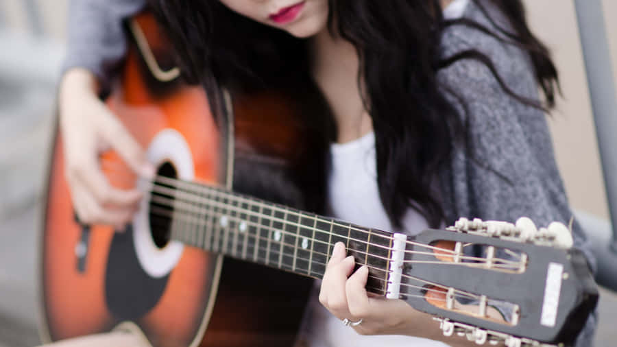 Ragazzache suona uno strumento musicale, immagine di chitarra
