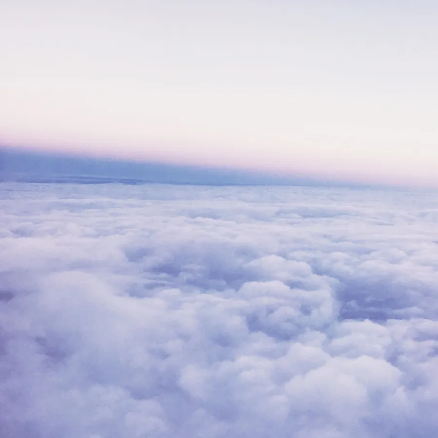 Periwinkle sky above clouds wallpaper