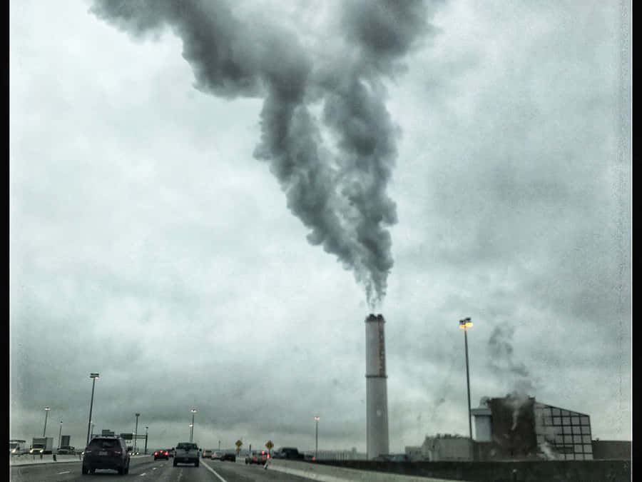 EinSchornstein, der Rauch auf einer Autobahn ausstößt.