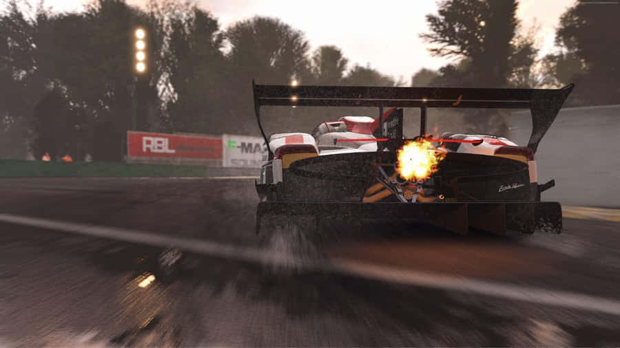 EinRennwagen fährt mit Flammen eine Rennstrecke entlang.