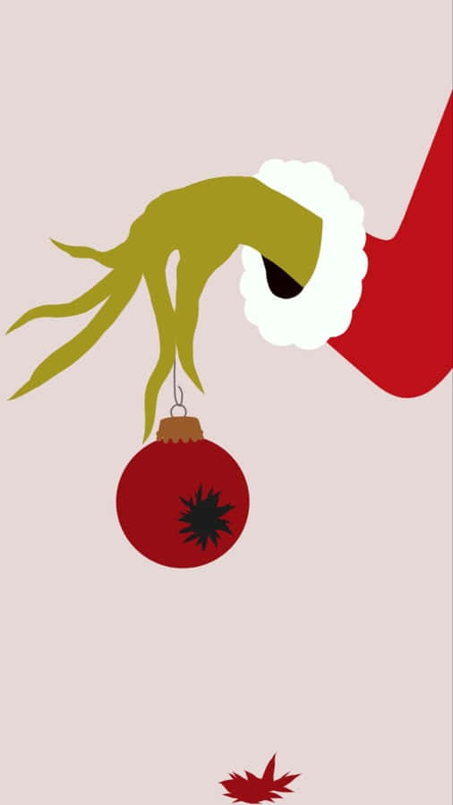 Grinch-Hand hält Weihnachtsornament