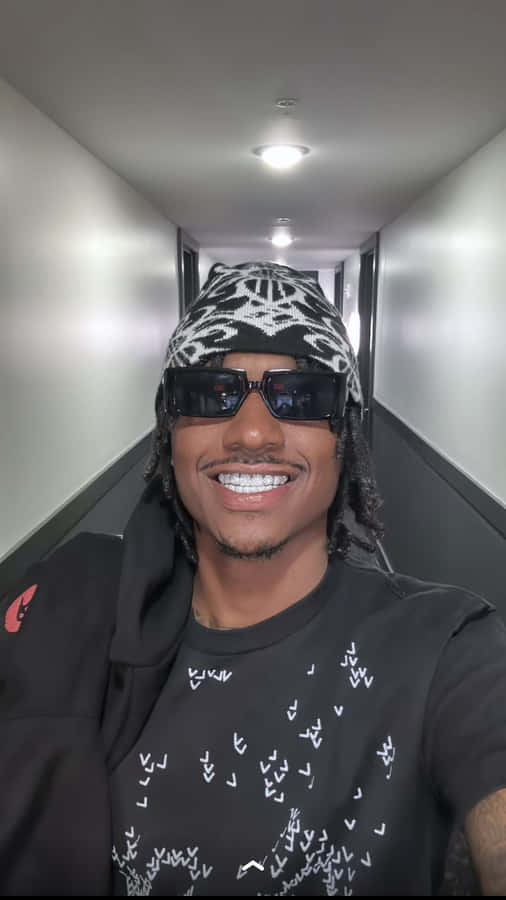 Lächelnder Mann mit Sonnenbrille und Mütze