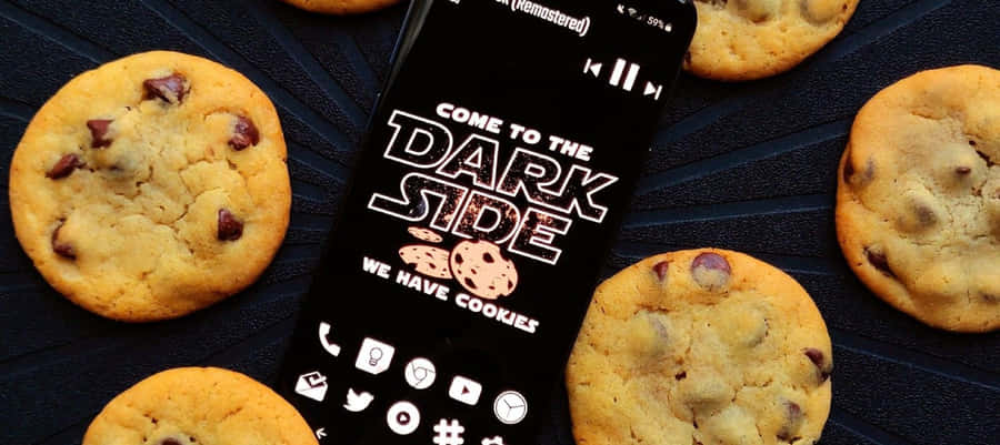 En telefon med cookies på det og ordene ”Kom til den mørke side”