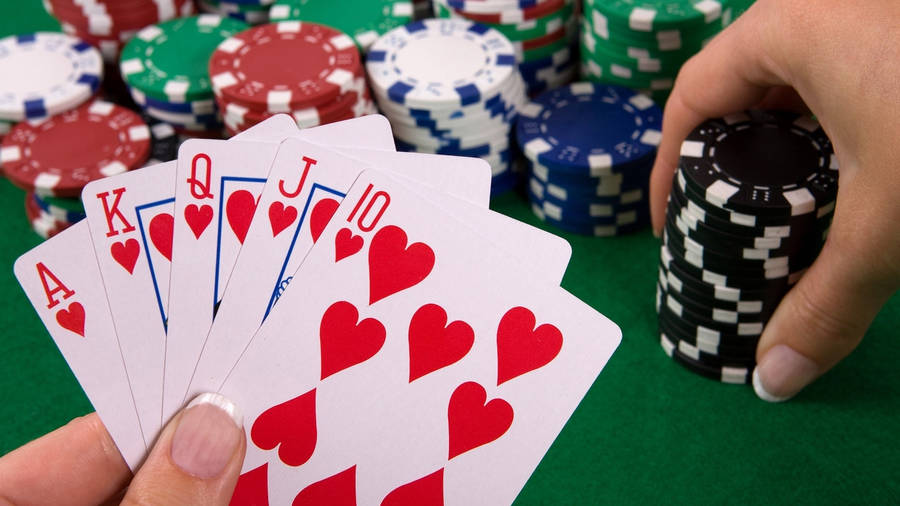 Mãosegurando um cartão Royal Flush no jogo de Baccarat