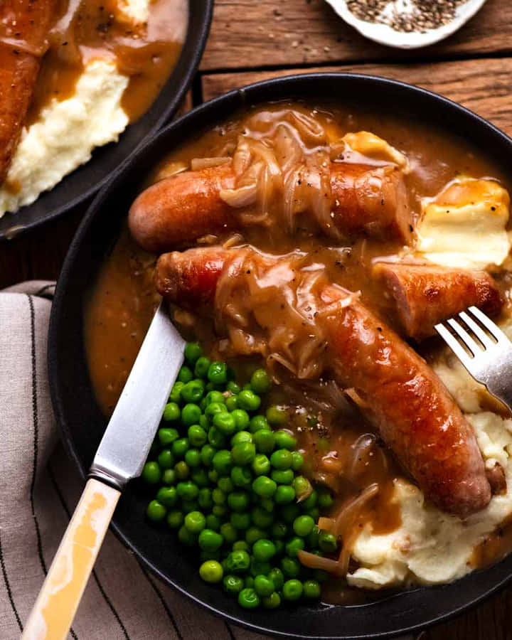 Salsichasdeliciosamente suculentas grelhando em uma frigideira