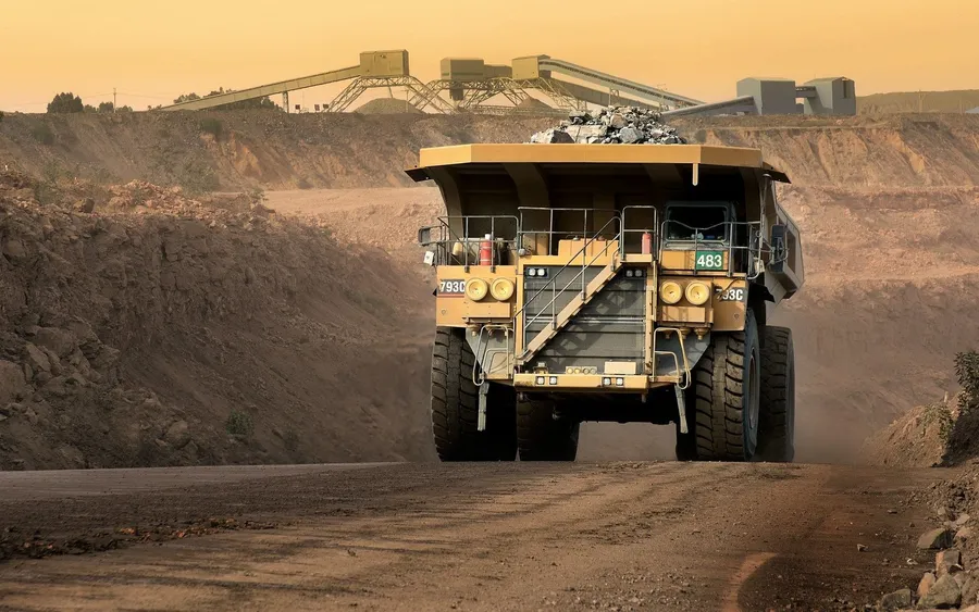 A miner operating heavy machinery in an underground mine