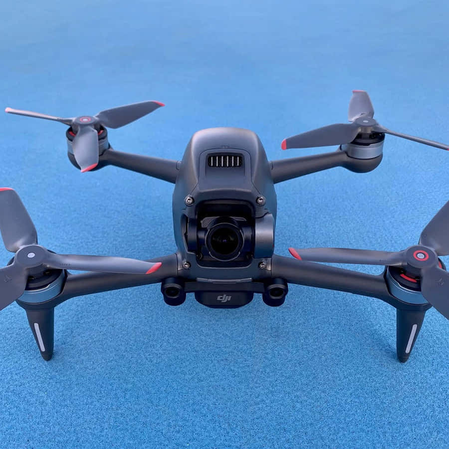 Umdrone preto com hélices em uma superfície azul
