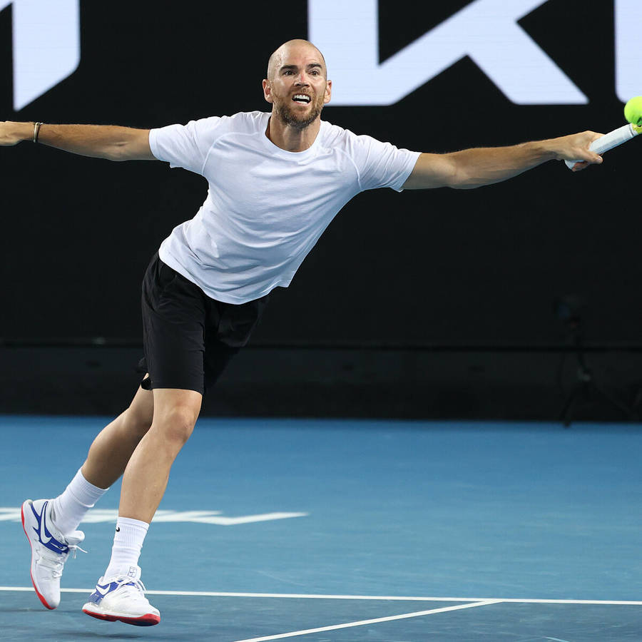 EinMann spielt Tennis.