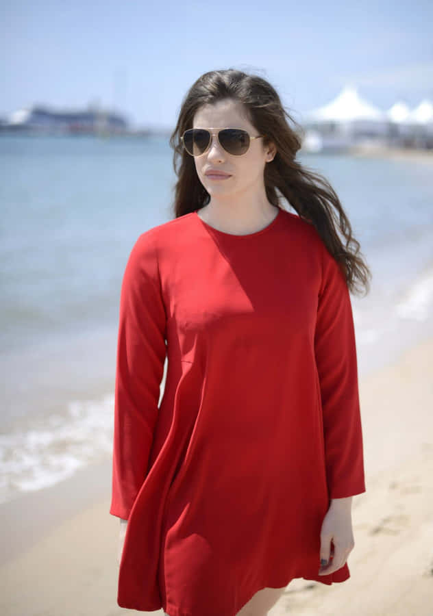 Passeggiata Elegante in Abito Rosso sulla Spiaggia