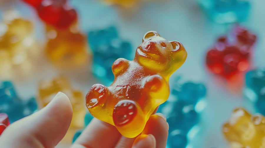 Bunte Gummibärchen in den Fingern
