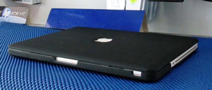Holddig ovenpå dit arbejde med en stilfuld sort MacBook.