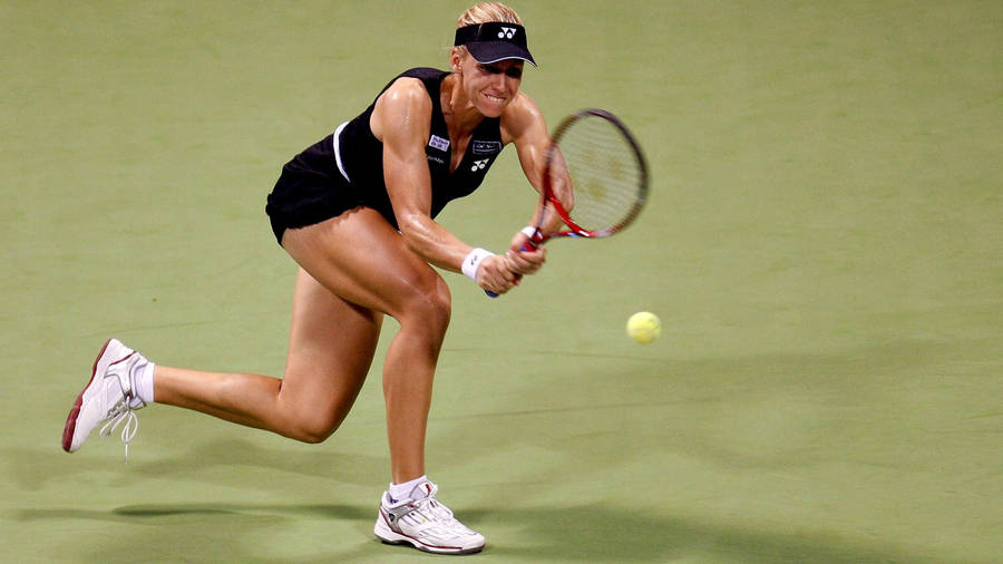 ElenaDementieva försöker träffa bollen. (This translates to "Elena Dementieva trying to hit the ball" in English. This sentence could be used as a caption for a wallpaper featuring Elena Dementieva playing tennis.)