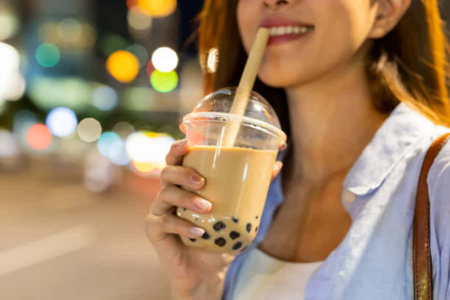 EineFrau trinkt nachts Bubble Tea.