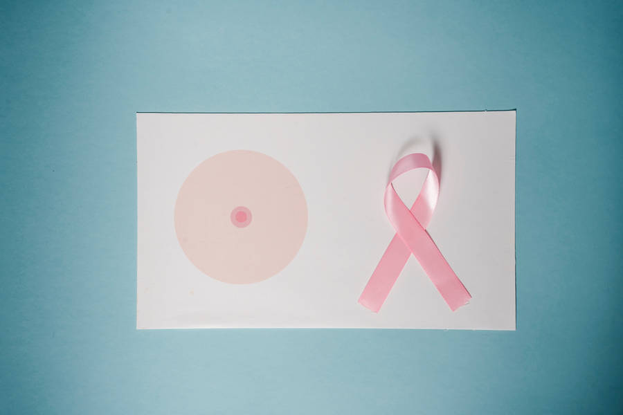 Blå kræft Awareness bånd mod en let pastel rosa baggrund.