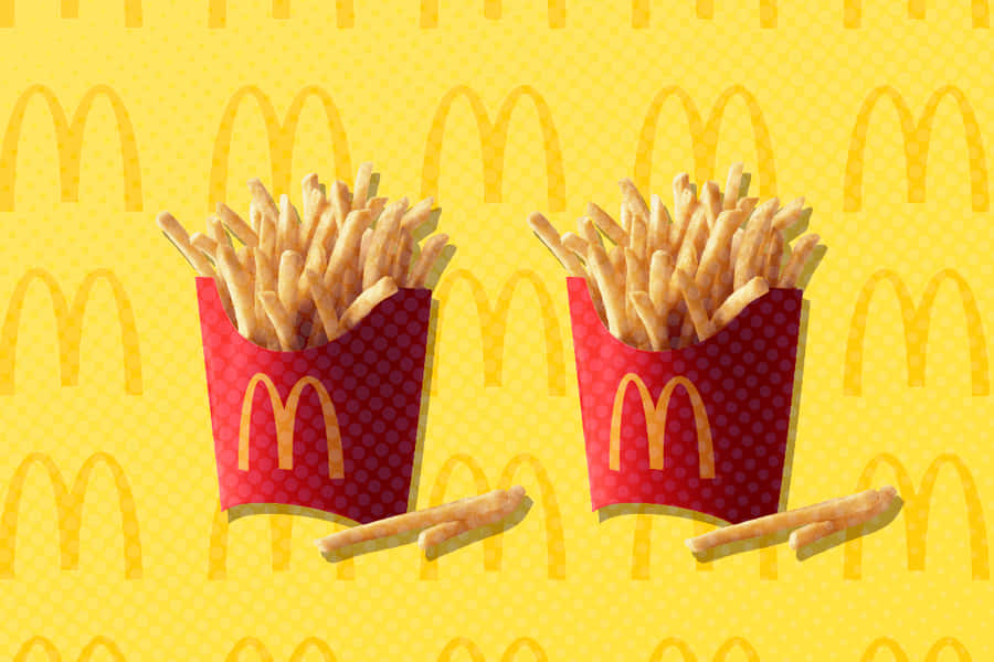 ZweiPommes Frites auf einem gelben Hintergrund.
