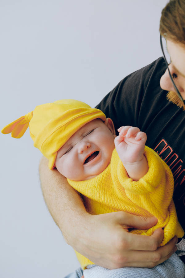 Bayi Imut Menangis Dalam Pakaian Kuning