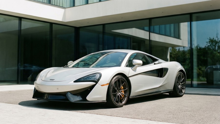 McLaren GT davanti a un'architettura moderna, elegante e minimalista.