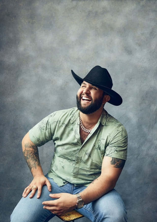 Homem Rindo com Chapéu Preto e Camisa Verde