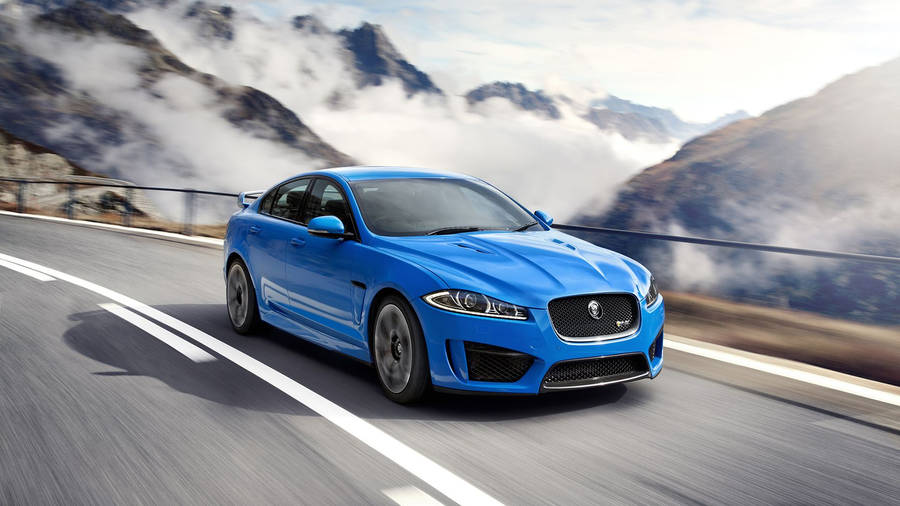 Download Blue Jaguar Car By Mountains Wallpaper | Wallpapers.com