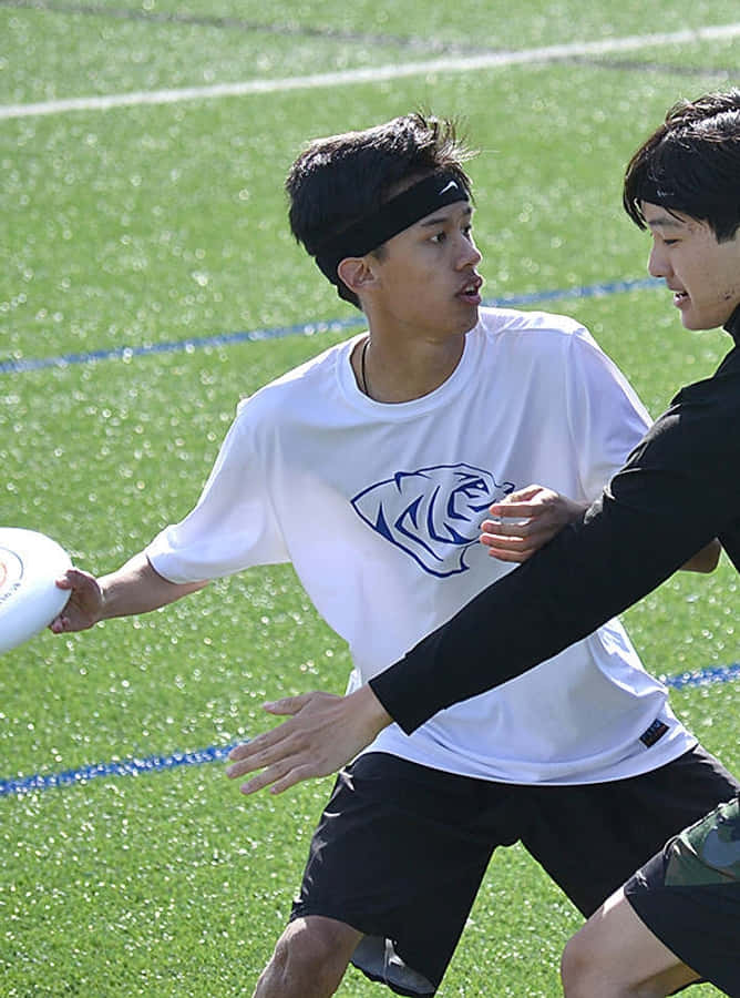 Asiatiske mandlige atleter, der spiller Android Ultimate Frisbee baggrund.