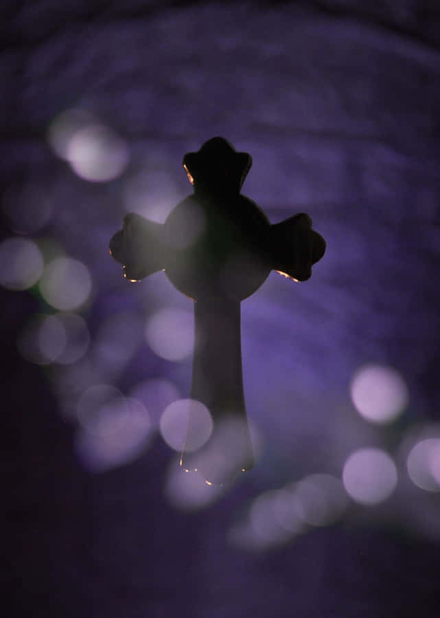Silhouettierte Kreuz gegen Bokeh-Lichter