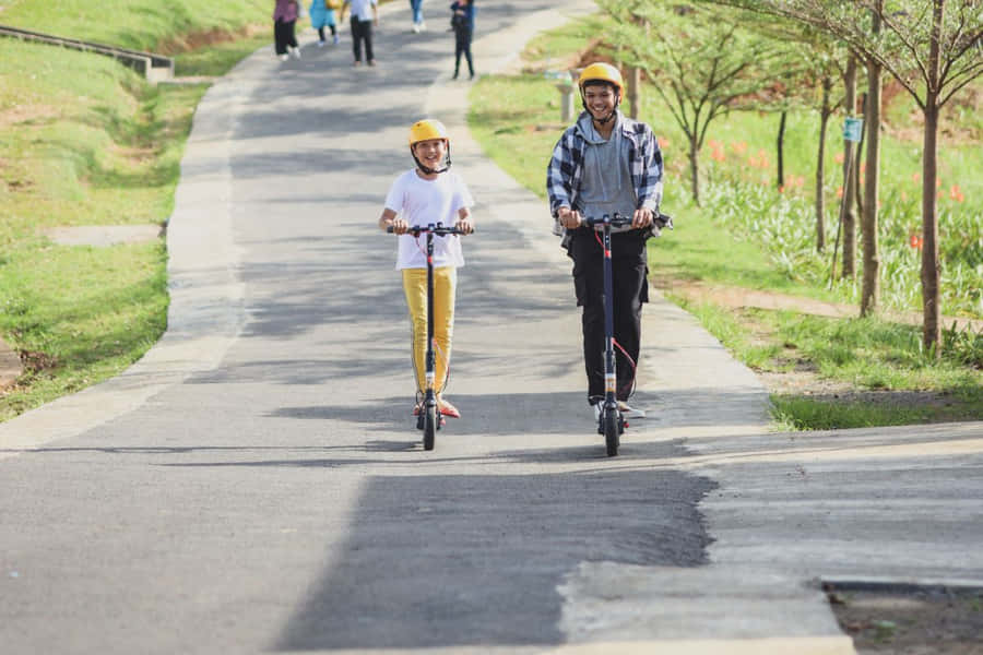 Imagemde uma Scooter com duas pessoas andando.