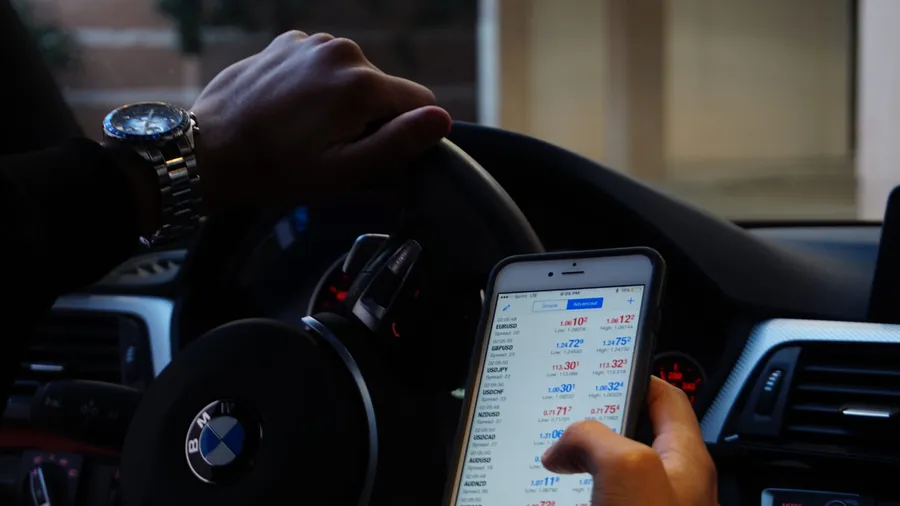 Hand Holding Phone with Foreign Exchange Rates