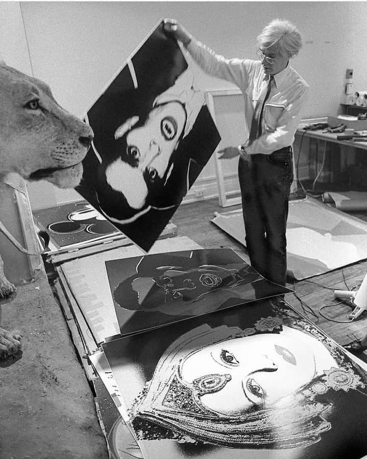 Etikonisk fotografi af kunstneren Andy Warhol, der ses mens han holder en pibe.