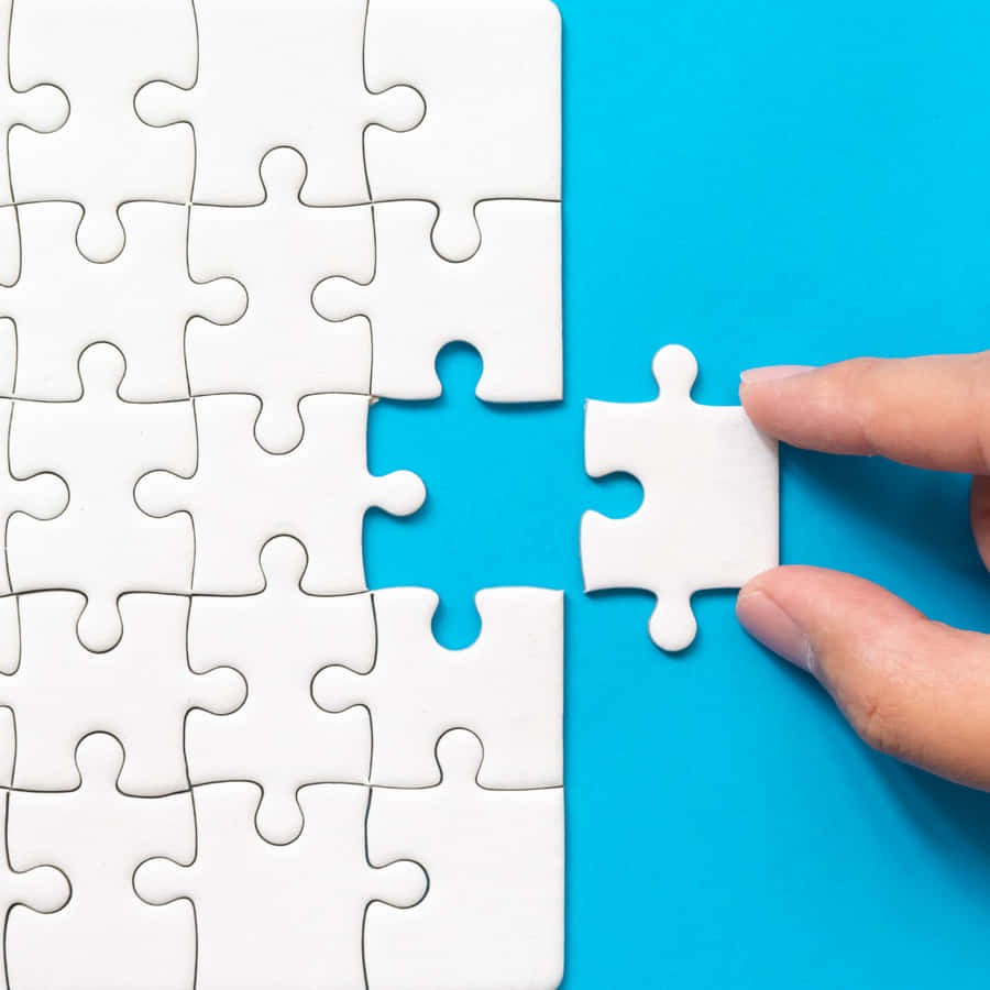 EinePerson hält ein Stück eines Puzzles.