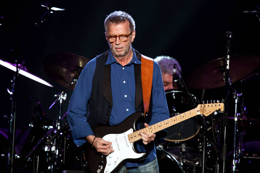 Download Eric Clapton Performing On Stage Wallpaper | Wallpapers.com