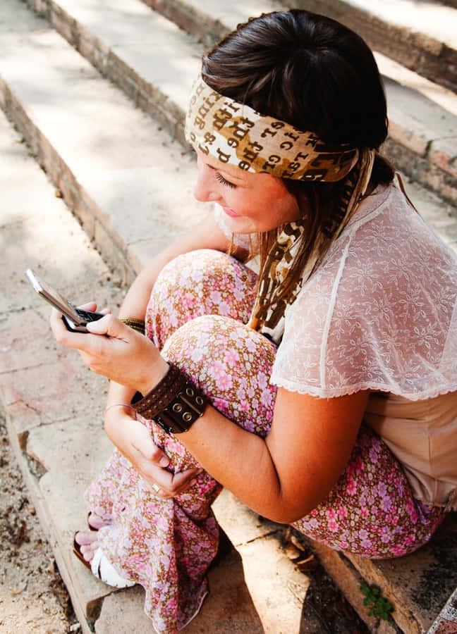 Donna Boho Chic che Usa il Telefono all'Aperto